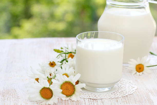 istock Fresh milk in glass on natural background 992619858