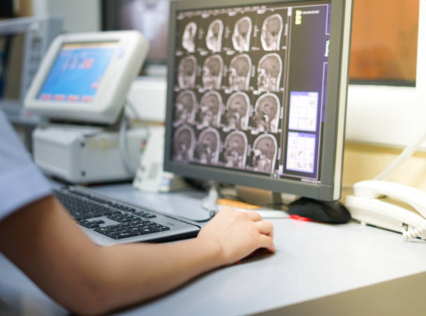 mri 室のワークステーションでの作業中の radiotechnologist 手持ち株マウス - mri scanner healthcare and medicine medical exam brain ストックフォトと画像