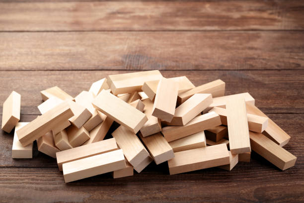 istock Heap of wooden blocks tower game on brown table 992653178