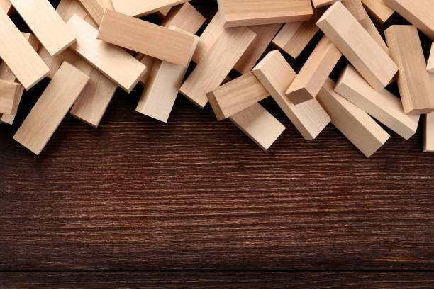 Heap of wooden blocks tower game on brown table