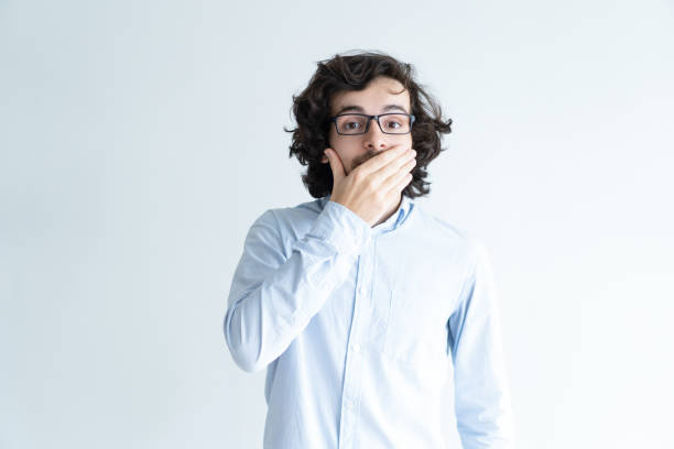 istock Surprised dark-haired man covering mouth with hand 992667912