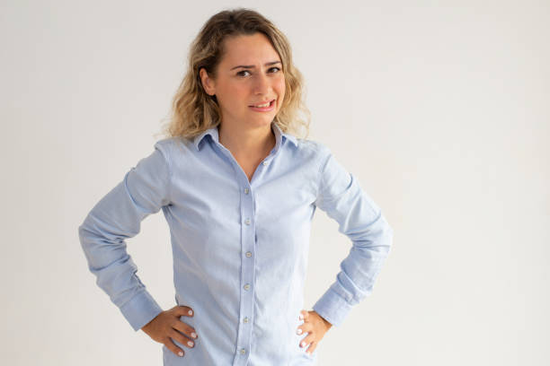 confused woman expressing disgust and looking at camera - facial expression unpleasant smell shirt caucasian imagens e fotografias de stock