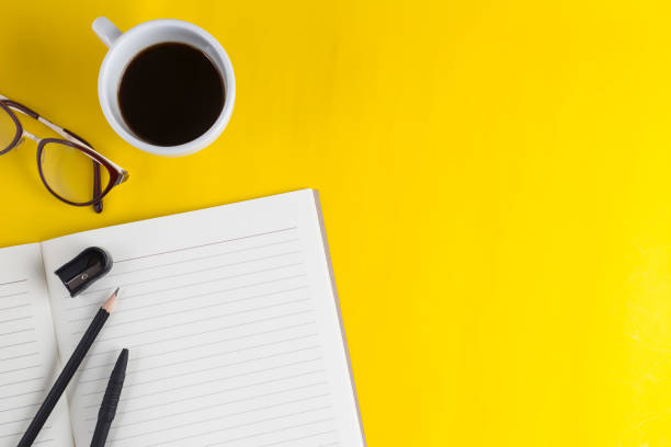 istock notebook open and coffee cup on desk color yellow 992691716
