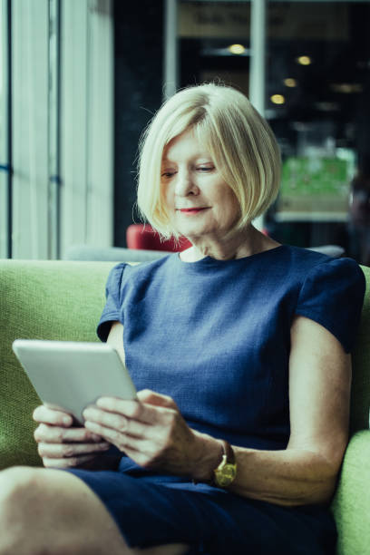 istock Concentrated woman reading article on tablet 992692398