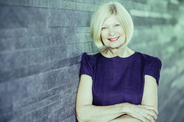 istock Happy beautiful female executive leaning on wall 992692402