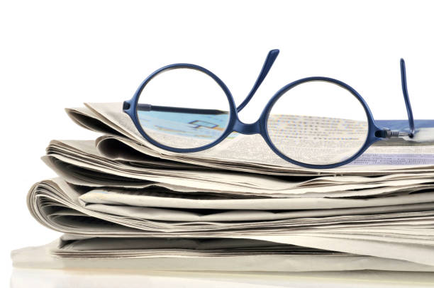 istock Pair of glasses placed on newspapers 992698610