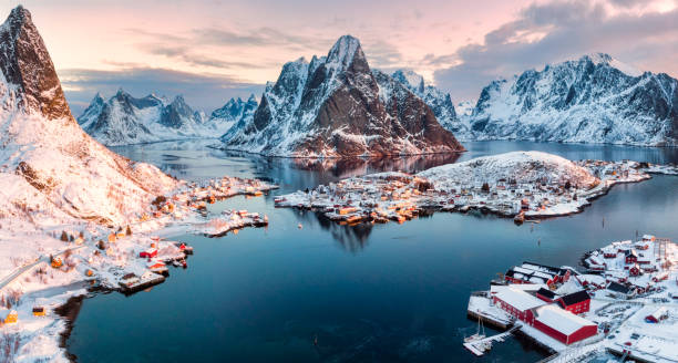 vista aerea del villaggio di pescatori in montagna circondata durante la stagione invernale - lofoten foto e immagini stock