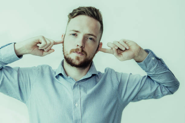 istock Serious Man Stopping Ears With Fingers 992710294