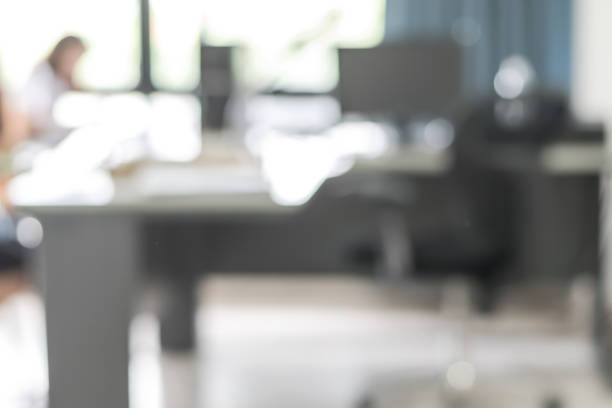 istock Blur background interior business office working space with pc personal computer screen in white room near glass window and wall 992714154