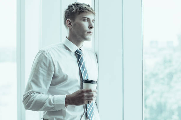 istock Serious Business Man at Window With Drink 992714360