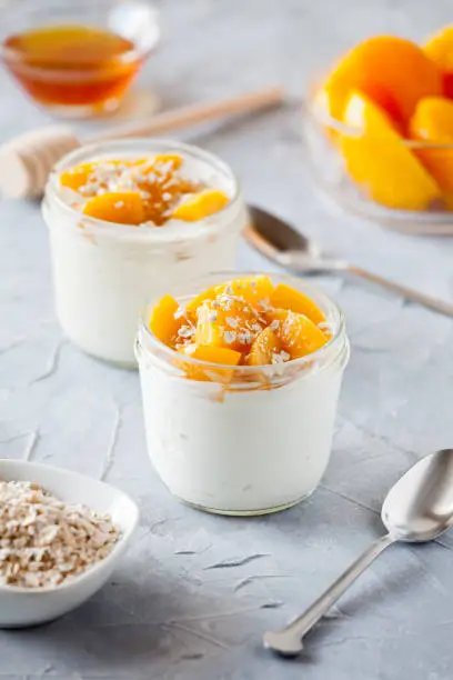 Couple of pots of yogurt with organic poached peaches