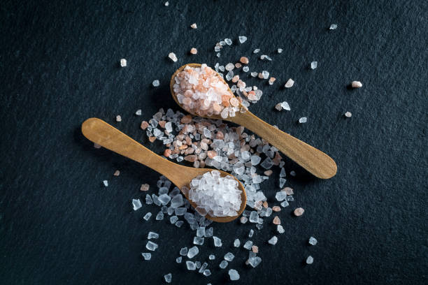 istock Two wooden spoons with pink himalayan and white kithchen salt 992726744