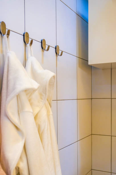 Close - up of white Terry bathrobes on bathroom background