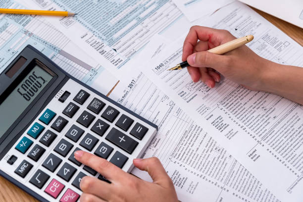 istock 1040 form with female hand, pen and calculator 992734142