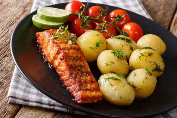 istock Spicy roasted salmon and boiled potatoes, fresh tomatoes close-up. horizontal 992734656