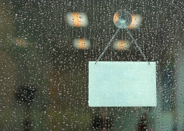 istock Rain drop with blank sign board hanging on glass door. 992744318