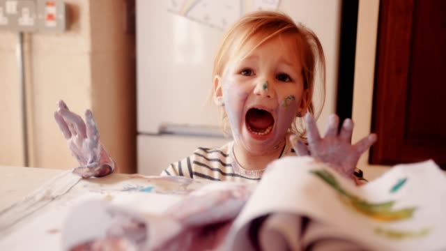Frustrated child dirty with paints having a tantrum