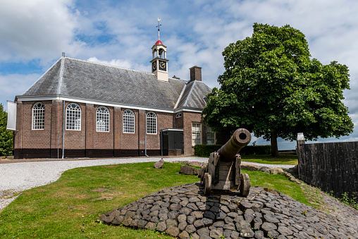Schokland, Netherlands, June 23, 2018: Church and cannon of former island Schokland, UNESCO world heritage site, in Flevoland, Netherlands.