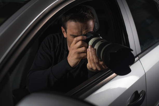 istock male paparazzi doing surveillance with camera from his car 992753170