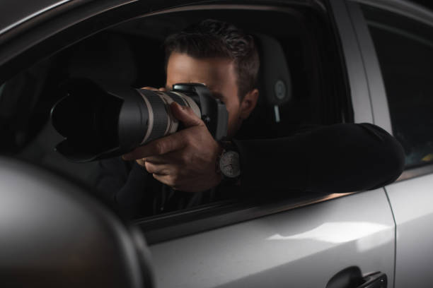 istock paparazzi doing surveillance by camera with lens from his car 992753328