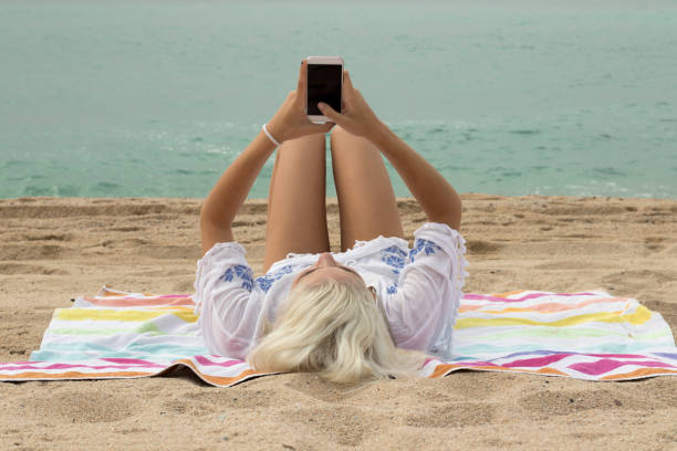 istock Woman using smartphone on the beach 992754062