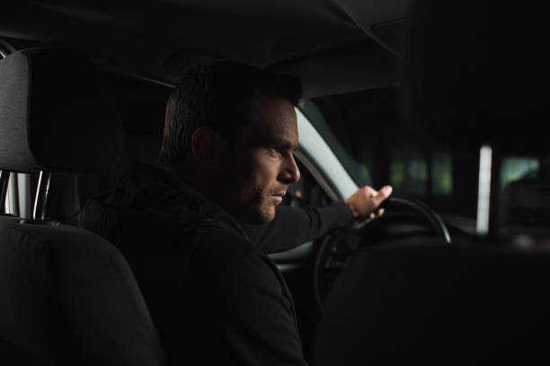 istock serious male private detective doing surveillance from his car 992754520
