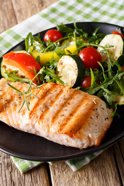 istock Dietary food: grilled salmon and vegetable salad with arugula closeup. vertical 992755182