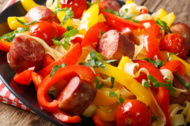 istock Stewed pepper with sausages and tomatoes close-up on a plate. horizontal 992758626