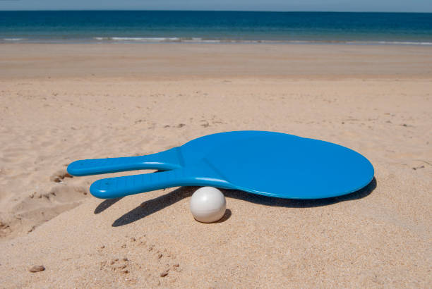racchette da beach tennis blu con palla sulla sabbia della spiaggia sullo sfondo del mare - matkot foto e immagini stock