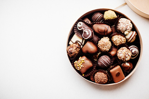 Round box of chocolates on white background. Assorted chocolates.