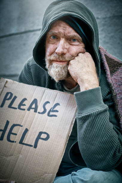 istock Pathetic male beggar with 'please help' sign 992778484