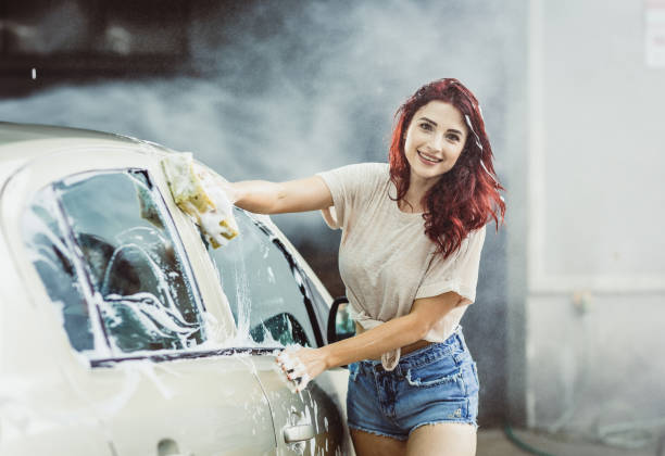 istock Young Woman Washing The Car 992787582