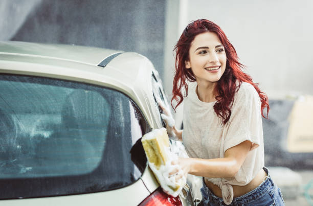 istock Young Woman Washing The Car 992787584