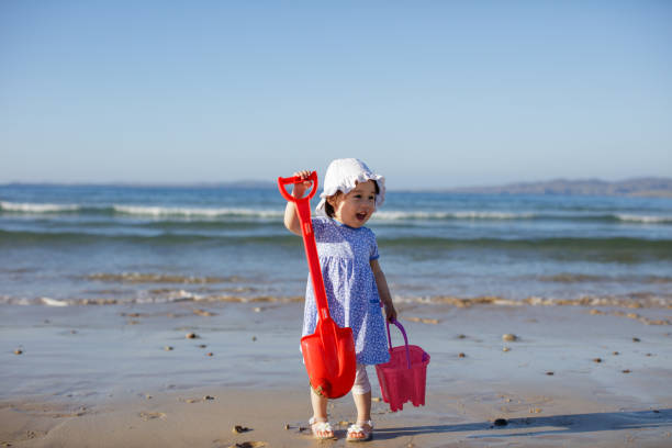 istock baby girl playing at summer beach 992787614