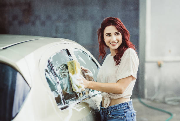 istock Young Woman Washing The Car 992787630