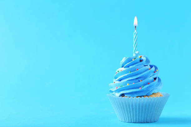 istock Tasty cupcake with candles on a blue background 992787922