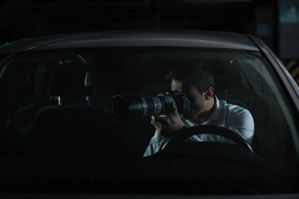 istock male private detective spying by camera with object glass from his car 992787980