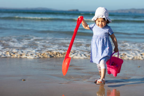 istock baby girl playing at summer beach 992787982