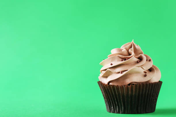 istock Tasty cupcake on a green background 992790446