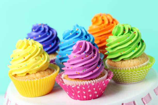istock Tasty cupcakes on cake stand on green background 992790602
