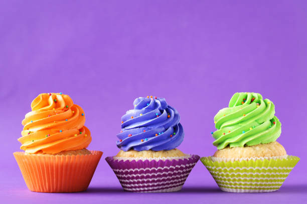 istock Tasty cupcakes on a purple background 992790642