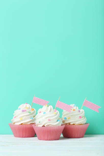 istock Tasty cupcakes on a green background 992790662