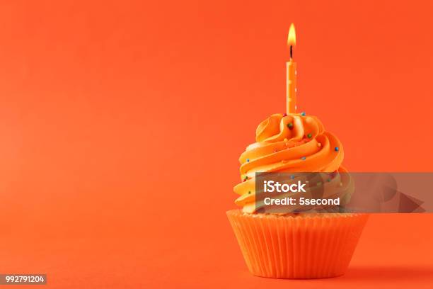 Leckere Cupcake Mit Kerze Auf Orangem Hintergrund Stockfoto und mehr Bilder von Orange - Farbe - Orange - Farbe, Cupcake, Feiern