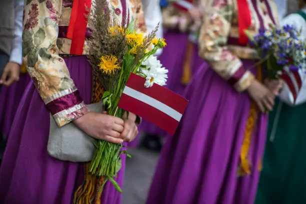 Photo of Song and dance festival in Latvia. Procession in Riga. Elements of ornaments and flowers. Latvia 100 years.