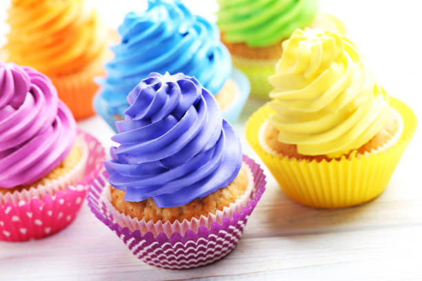 istock Tasty cupcakes on a white wooden table 992793900