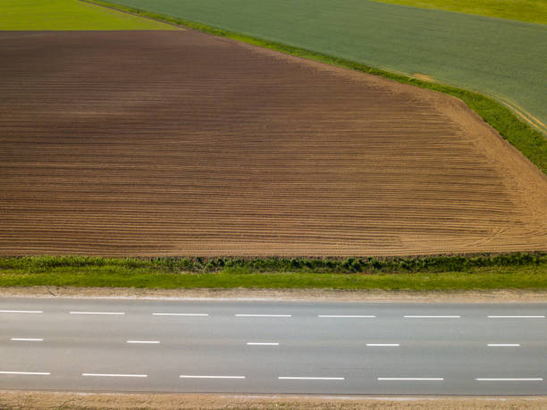 istock Spring arable land. A field and  road. View from above. 992795336