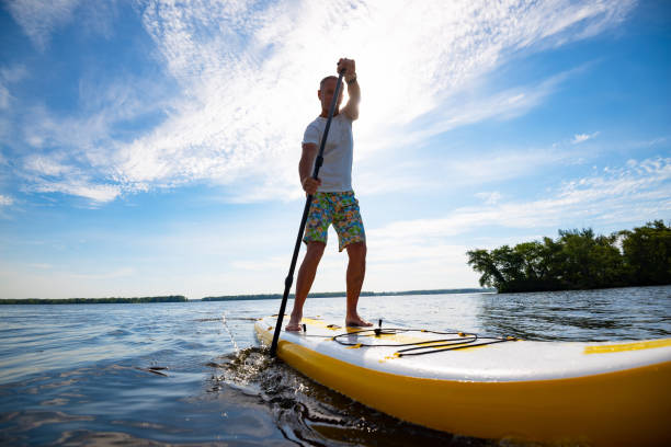 istock Joyful man sails on a SUP board in large river 992795422