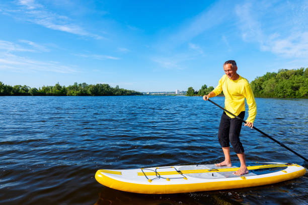 istock Joyful man sails on a SUP board in large river and enjoying life 992795472