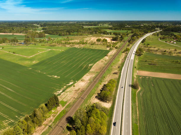 istock High-speed highway and railway, top view. Green field and blue sky. 992799258