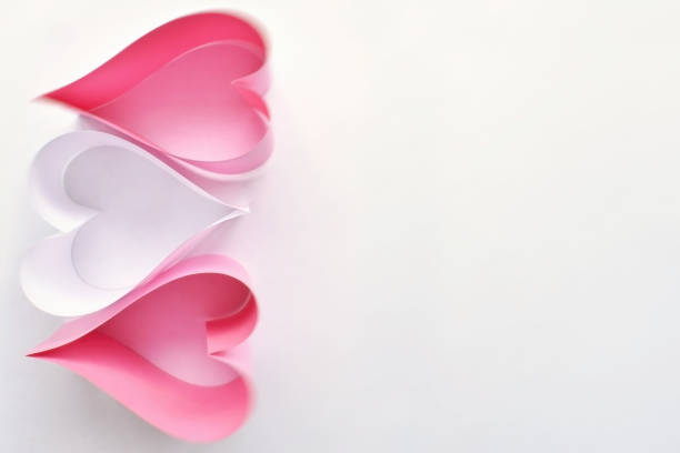 istock Pink and white paper hearts on white background. 992811416